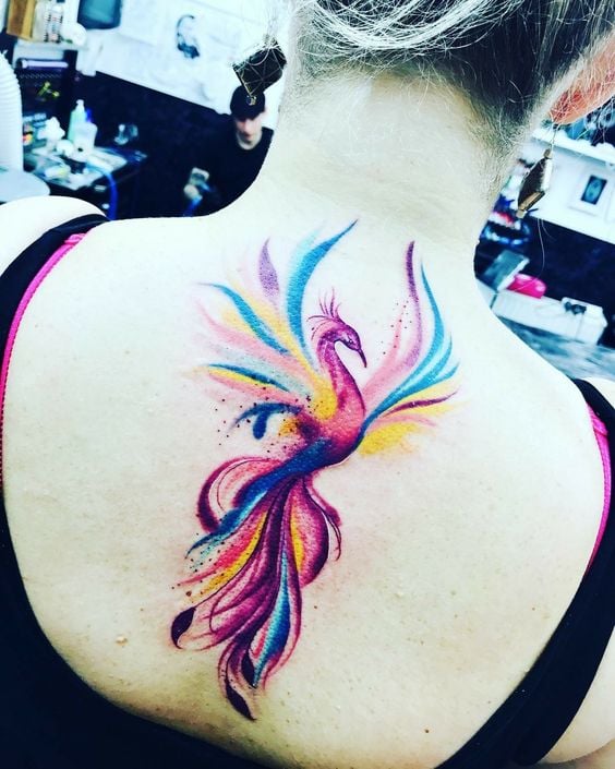 196 Tatuajes en la Espalda Ave Fenix multicolor entre los omoplatos violeta celeste fucsia