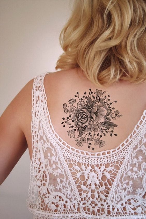 203 tatuagens nas costas de uma mulher Motivo floral entre as omoplatas pretas