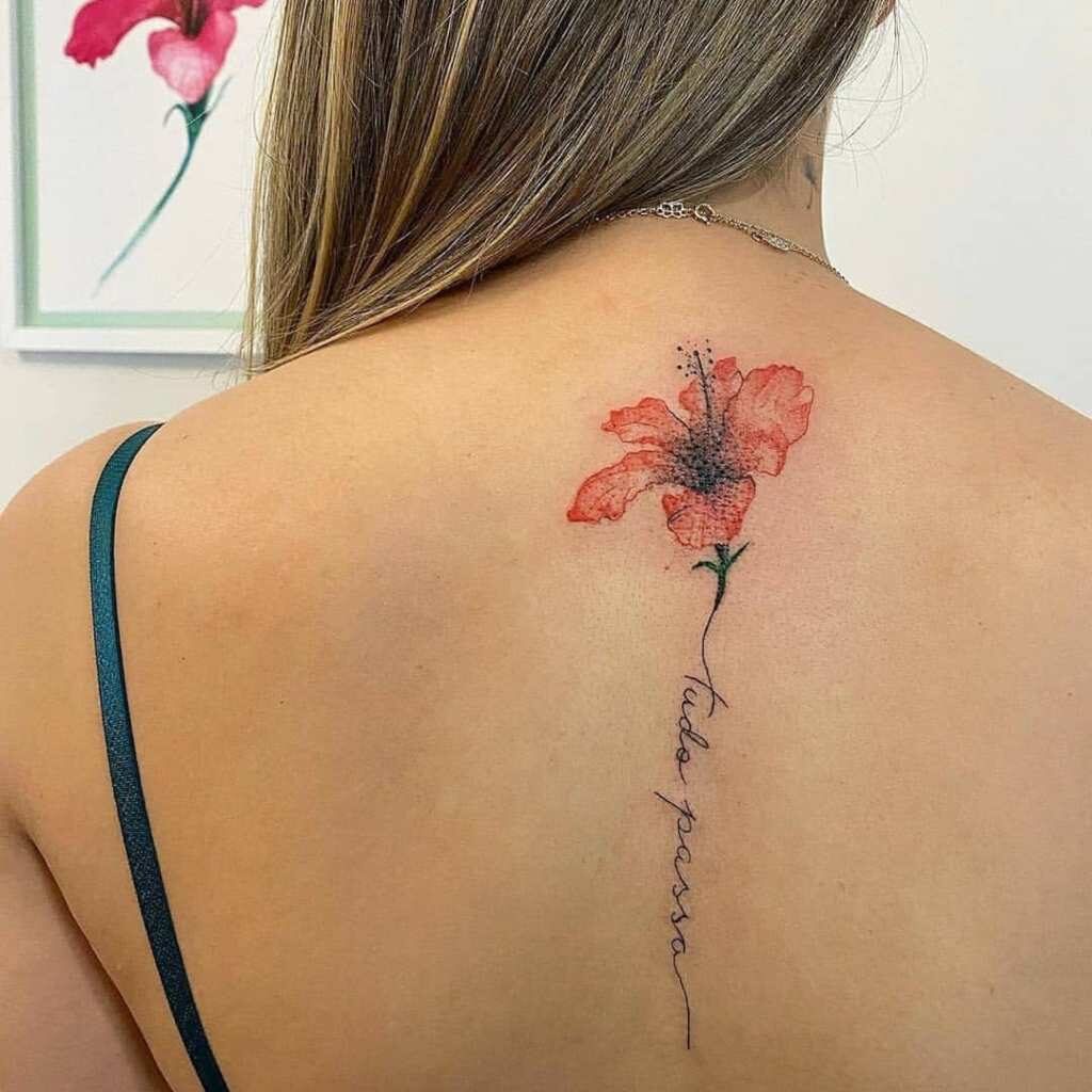 21 Tatuagens nas costas de uma mulher Flor vermelha tipo sino e inscrição ao longo da coluna tudo acontece tudo acontece