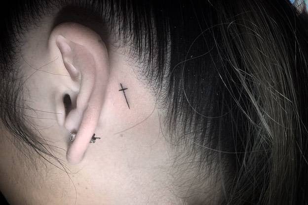 25 Tattoos hinter dem Ohr Sehr kleines Kreuz aus zwei feinen schwarzen Linien