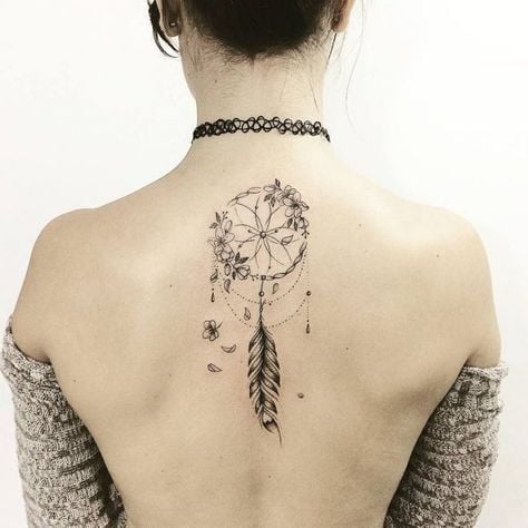 28 Tattoos on Back Woman Catcher Dreams with feather and flowers in black in the middle of the shoulder blades