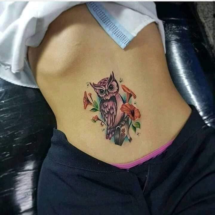 3 TOP 3 des tatouages féminins les plus appréciés Hibou avec des fleurs orange et des feuilles vertes sur l'abdomen