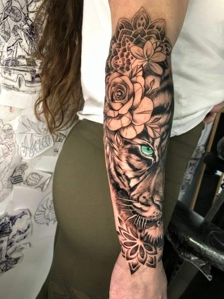 31 Leone tatuaggio sull'avambraccio con fiori mandala occhi azzurri