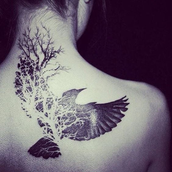 36 tatuagens nas costas mulher corvo negro com galhos de árvores mortas na nuca