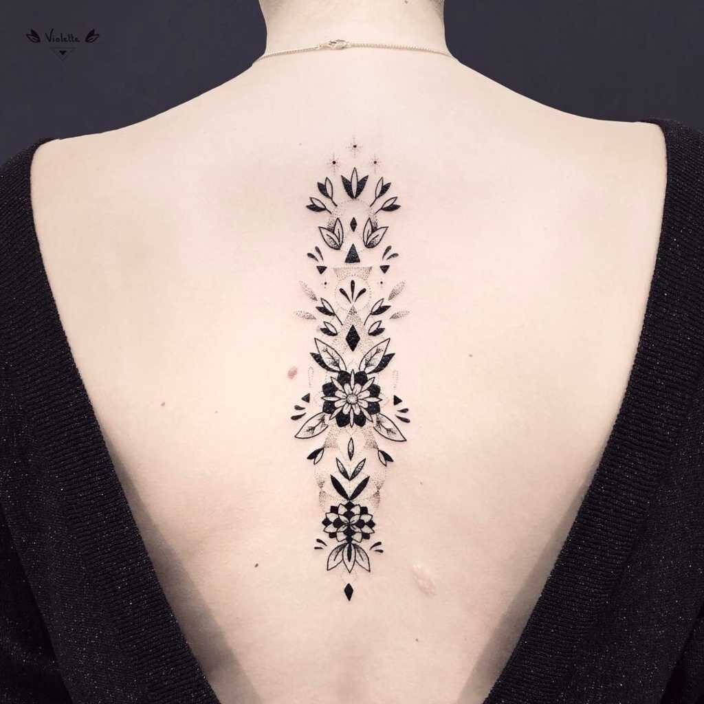 52 Tattoos on the Back of Women Black Flowers stars and geometric patterns on the spine