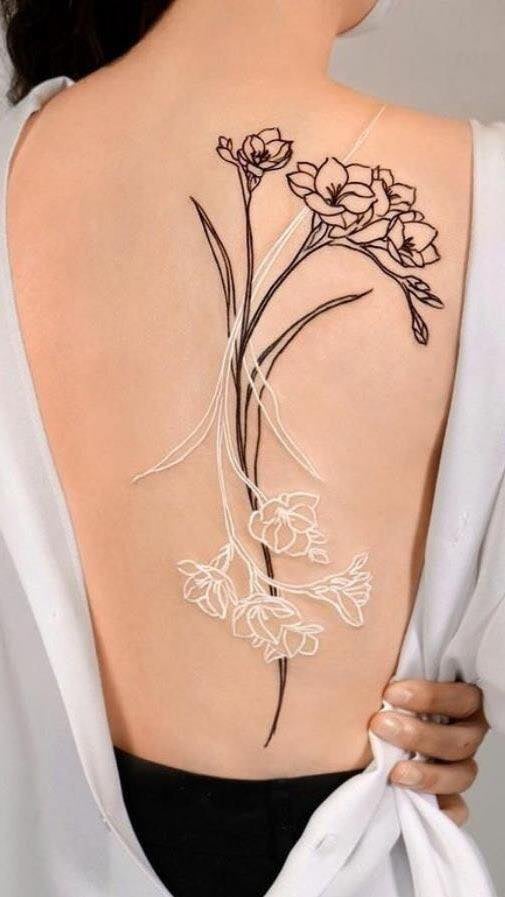 81 Tatuajes en Espalda Mujer Contorno de Flores con Tinta Negra y Tinta Blanca como una imagen espejada trabajo de Artista