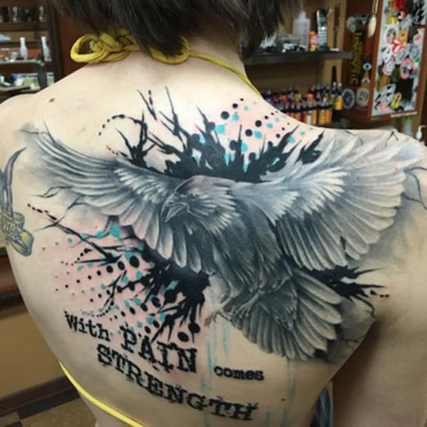 Tatuajes Espalda Mujer Hermosos Cuervo Negro Grisaseo con fondo negro tipo acuarela con inscripcion With Pain Comes Strength Con el Dolor viene la Fuerza