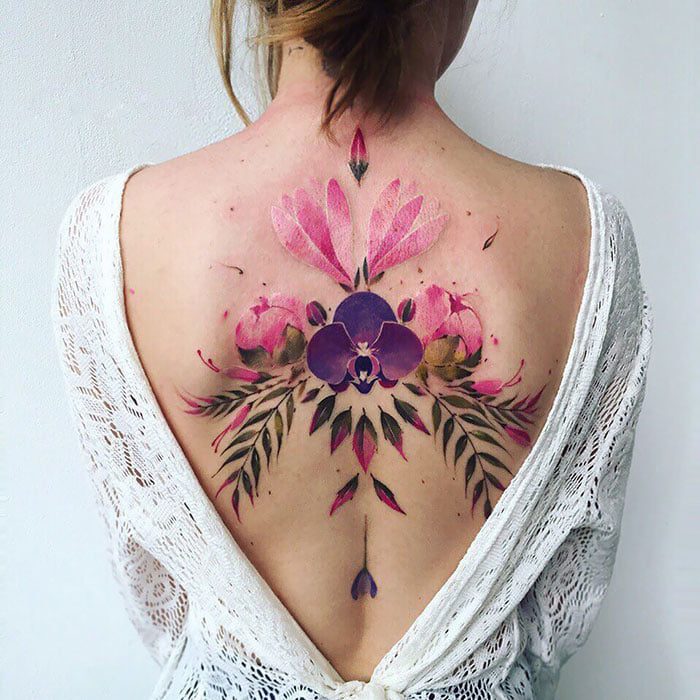 Tatuajes Espalda Mujer Hermosos Gran motivo Full Color Flor Violeta al centro Flores rosas y Hojas con simetria perfecta espejada en la columna
