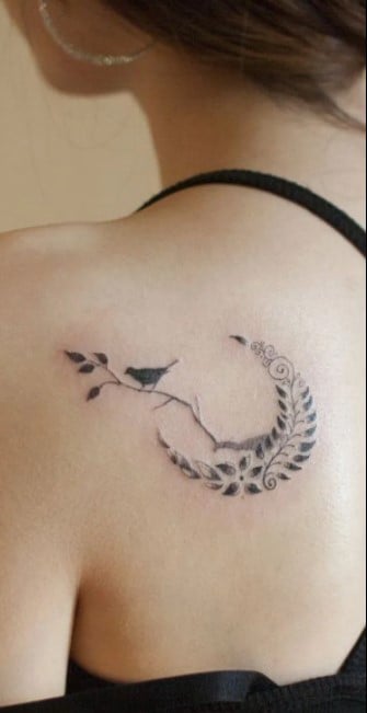 Beautiful Women's Back Tattoos on Shoulder Blade crescent of fern and bird perched on black twig