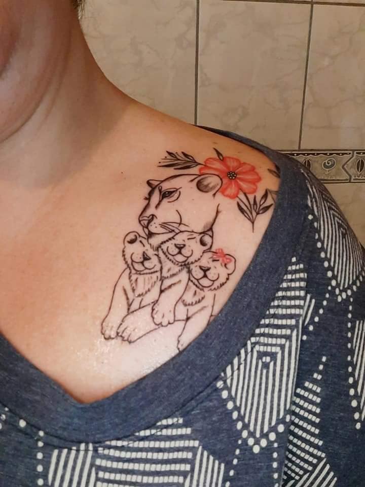 Most liked female tattoos in clavicle area Lioness with three cubs, one girl and two children and red flower on shoulder