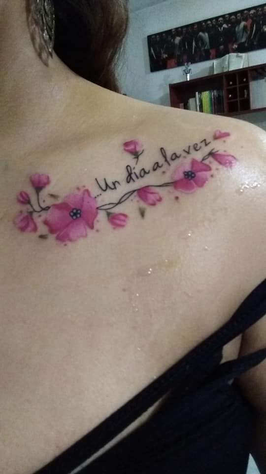 Women's most liked tattoos beautiful bouquet of pink flowers with the inscription one day at a time on clavicle