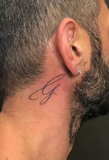 Tatuajes con la letra G ge con trazo fino detras de la oreja en imprenta minuscula
