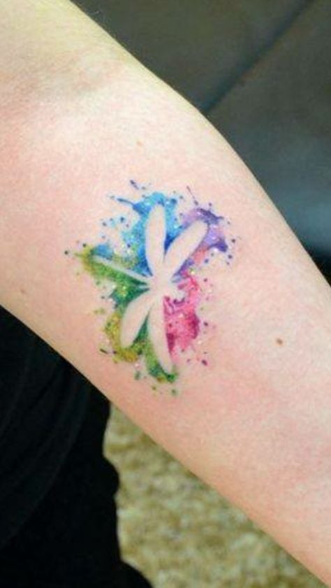 Tatuaggi ad acquerello con libellula nei colori azzurro, viola, rosso e verde che definiscono il contorno della libellula