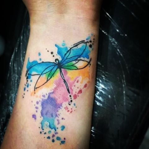 Tattoos of multicolored watercolor dragonflies on the wrist