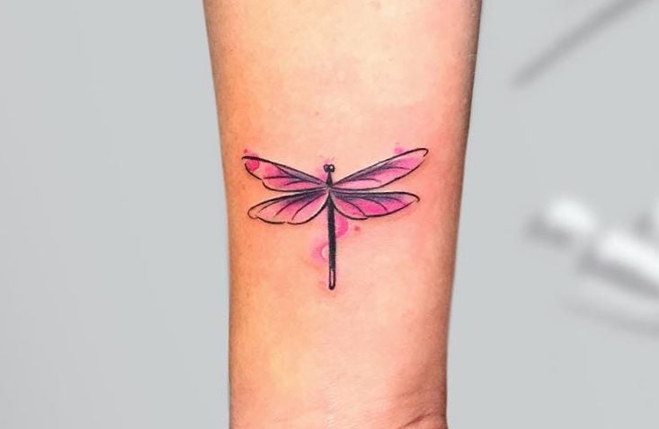Tatuaggi di libellula in rosso sul braccio