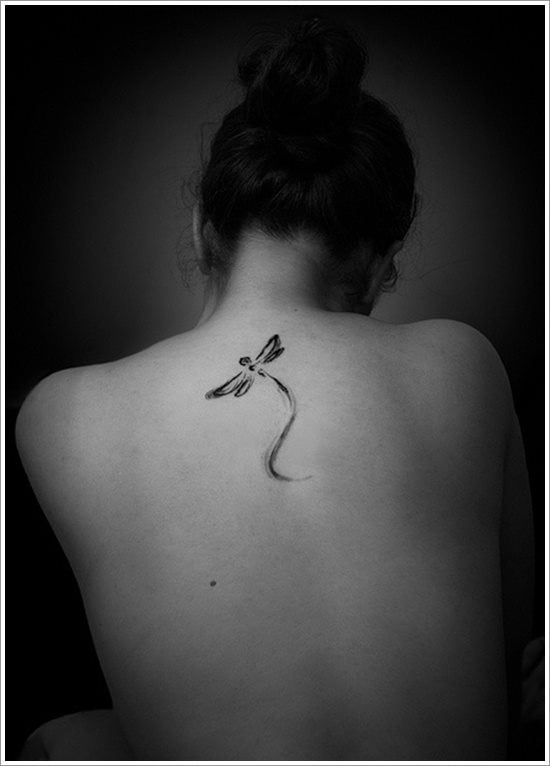 Small black dragonfly tattoos between the shoulder blades on the back