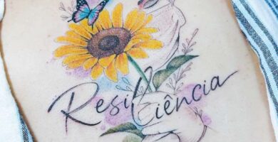 1 TOP 1 Artista Jacke Michaelsen BR Tatuajes Gran Girasol en Espalda con la Palabra Resiliencia Manos Mariposa Rostro Colores Amarillo Verde 1