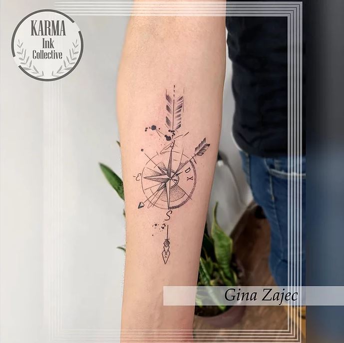 10 Karma Ink Collective Tatuaje Rosa de los Vientos en Antebrazo atravesado por Plumas Autor Gina Zajec
