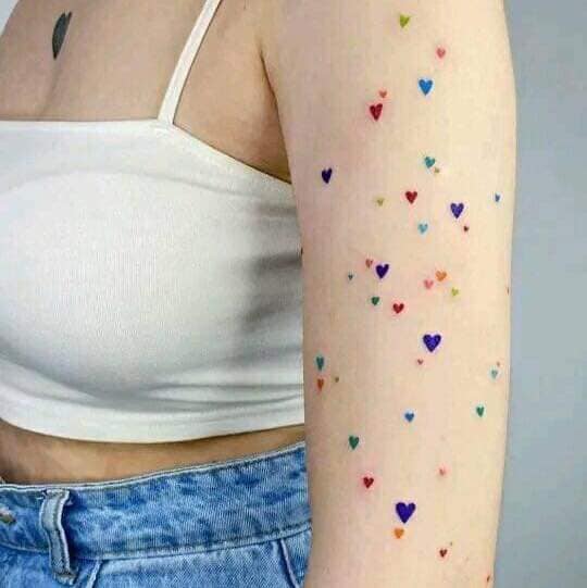 106 Tanti mini tatuaggi a cuore di diversi colori su tutto il braccio