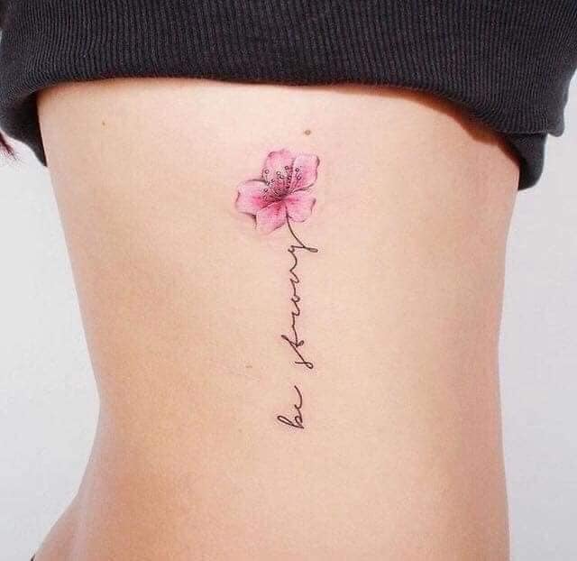 109 tatuagens simples, fofas e estéticas flor de papoula rosa com inscrição nas costelas