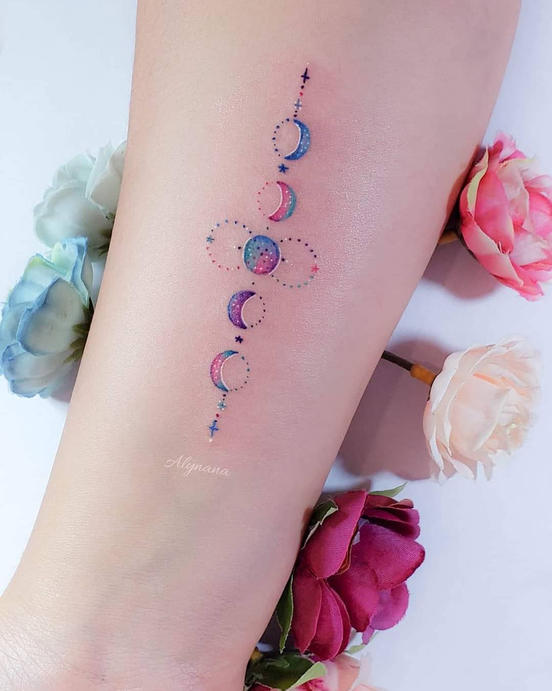 157 Delicati tatuaggi colorati dell'artista Alynana Moon Phases con piccoli punti e stelle sull'avambraccio