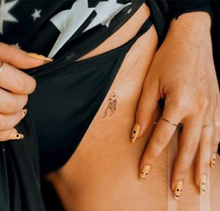 19 Tatuaje de Alas Pequena mano con estrellas en el costado del pecho