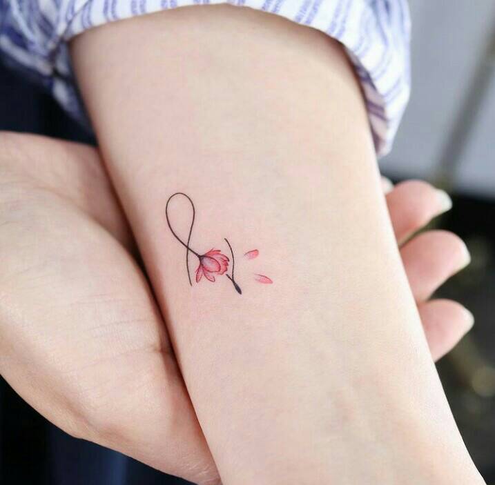 26 Delicate half infinity tattoos with a small fuchsia flower on the arm