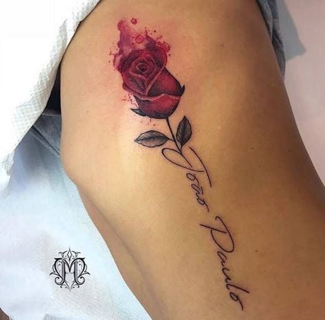3 TOP 3 Tattoos mit Blumen auf den Rippen Aquarellroter Rosensetzling mit schwarzen Blättern und Inschrift als Paulo-Stiel