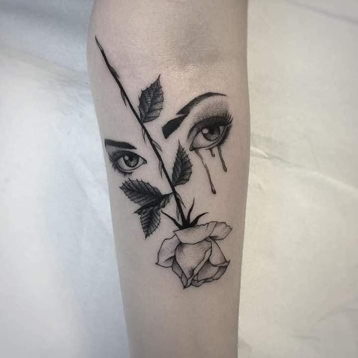3 TOP 3 Tattoos für Frauen, die am meisten gefallen: Augen einer weinenden Frau und durchgehend Rose mit schwarzen Dornen auf dem Unterarm