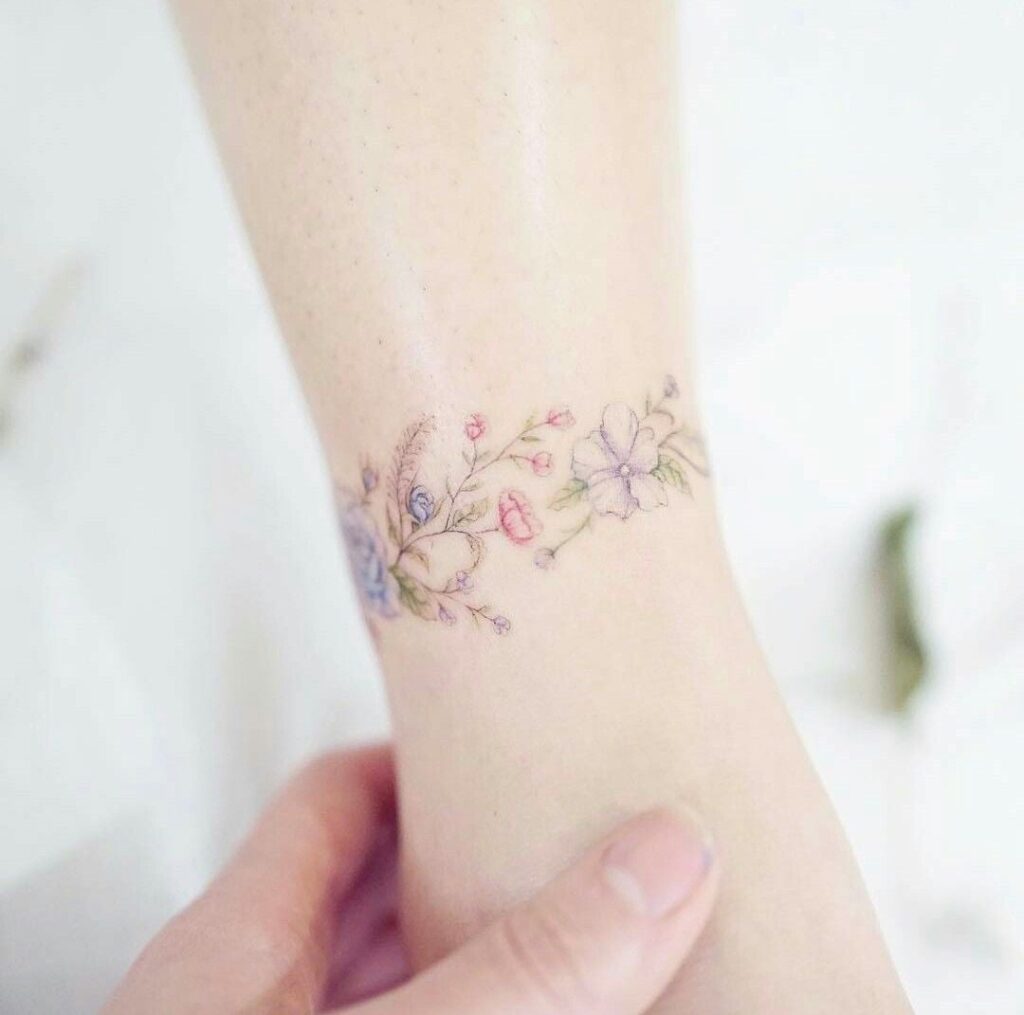 43 Delicate Tattoos Bracelet of small violet pink flowers on the calf