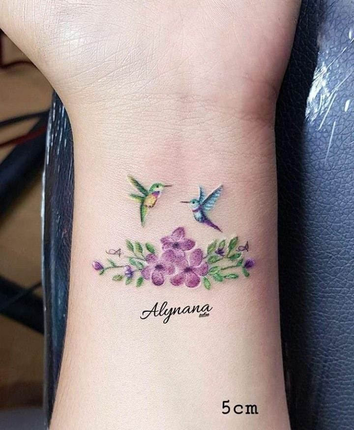 5 TOP 5 Estudio Alynana Tattoo CDMX on Wrist Bouquet of violet flowers leaves two Hummingbirds one green the other blue Children