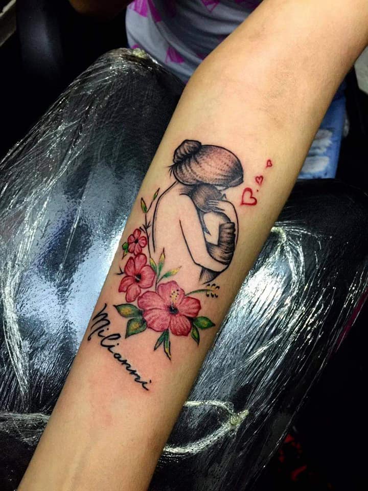 7 Most liked Women's Tattoos July part 2 Mother Embracing Baby with red flowers and name milianni with three hearts on her arm