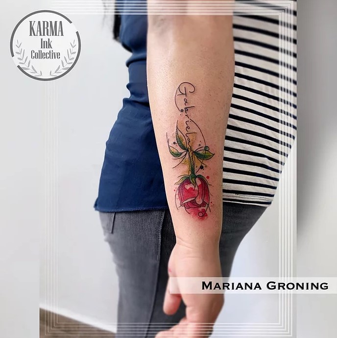 8 Karma Ink Collective Tattoo Rose on forearm with Green Leaves Stem and name Gabriela Author Mariana Groning