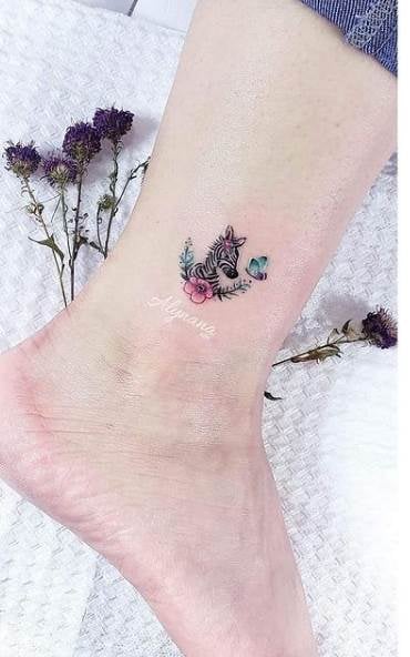 Alynana Tattoo Studio CDMX Zebra no tornozelo com florzinhas e borboleta