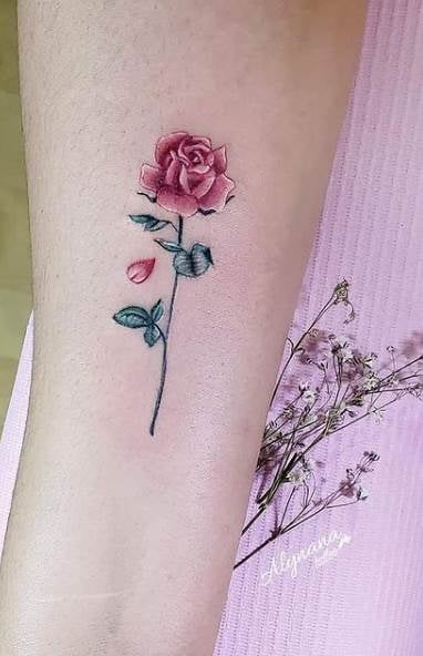 Alynana Tattoo Studio CDMX einfache und schöne Rose mit einem Blütenblatt, das auf der Wade fliegt