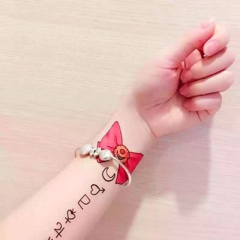 Meilleurs tatouages de Sailor Moon Usagi Bunny Serena tsukino symboles de singe kawaii sur le poignet en rouge