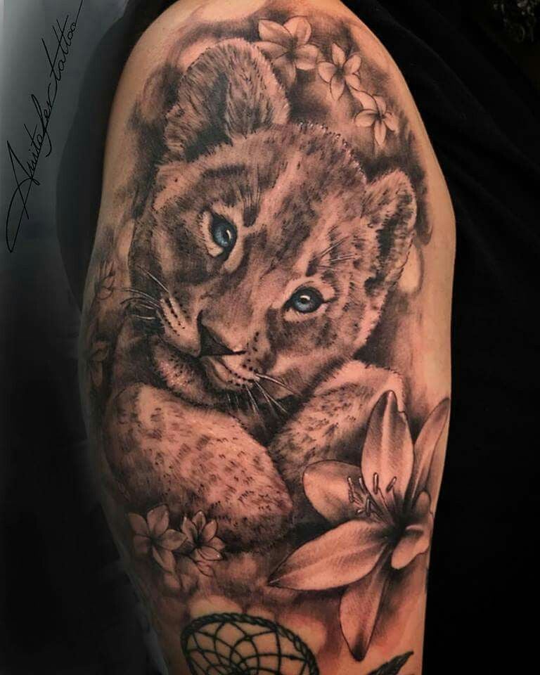 Tattoo of Lioness and her Cubs Realistic close-up of Cub's face with light blue eyes Flowers and below Dreamcatcher