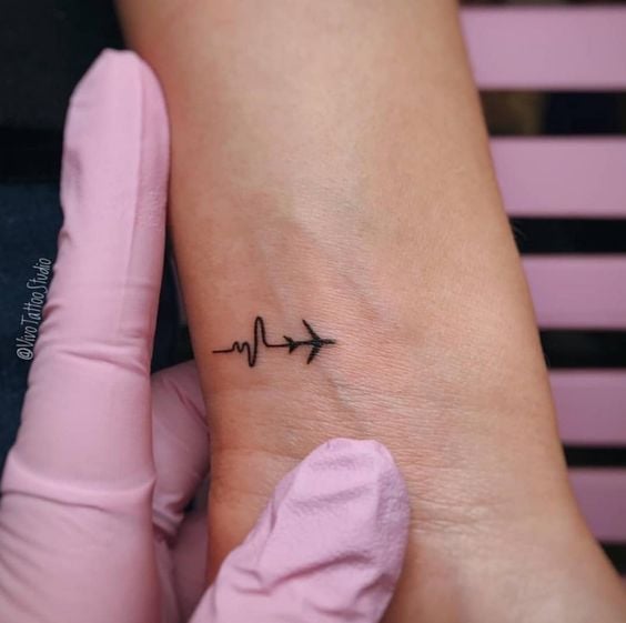 Tatuagens Cardio Simples Bonitas e Estéticas que continuam na esteira de um pequeno avião no pulso