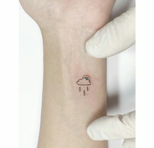 Simple Cute and Aesthetic Tattoos cloud with rain and small rainbow on wrist