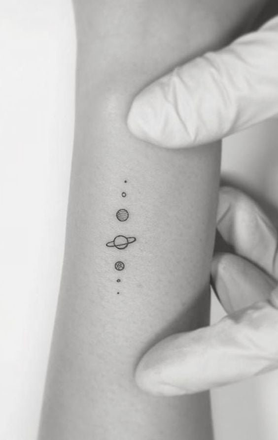 Einfache, niedliche und ästhetische Tattoos mit kleinen Kreisen, die das Sonnensystem mit Jupiter in der Mitte darstellen