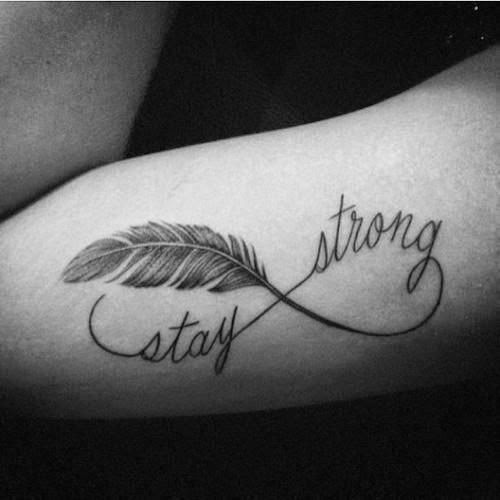 Tatuajes de Amor Infinito en Negro con delicada pluma y las palabras Stay Strong Mantenerte fuerte