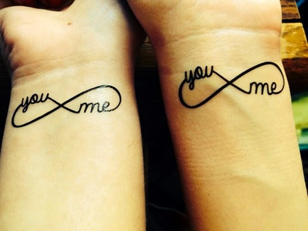 Unendliche Liebes-Tattoos auf den Handgelenken von Paaren mit den englischen Worten „you me your me“.
