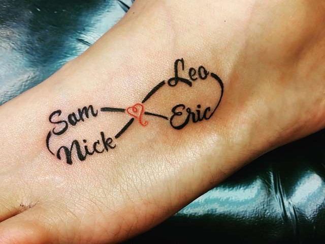 Tatuajes de Amor Infinito en pie con pequeno corazon rojo al medio y nombres Sam Mick Leo y Eric