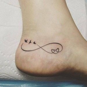 Small Infinite Love tattoos on the foot near the top of the heel on one side three sea lions two hearts and fine lines