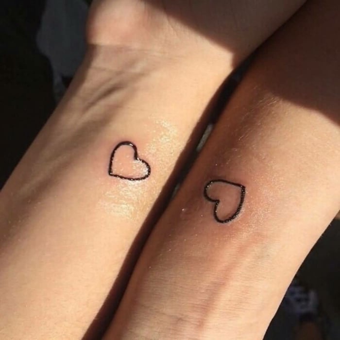 Herz-Tattoos für Paare, Schwestern, Freunde in feiner schwarzer Kontur auf den Handgelenken