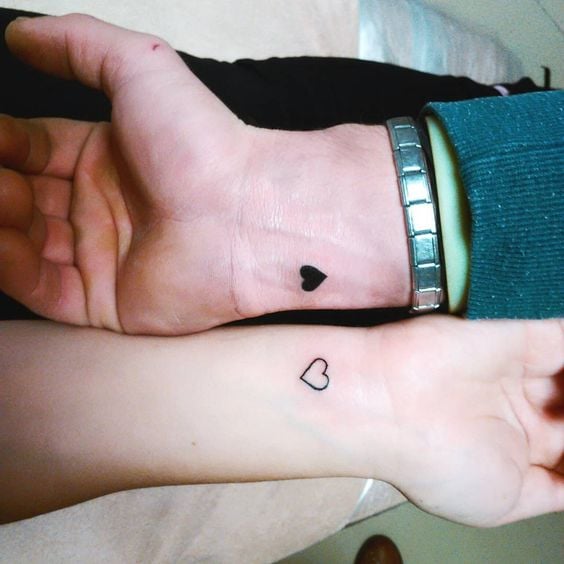 Tatuaggi a cuore per coppie, sorelle e amici sui polsi, uno completamente nero, un altro complementare, solo il bordo