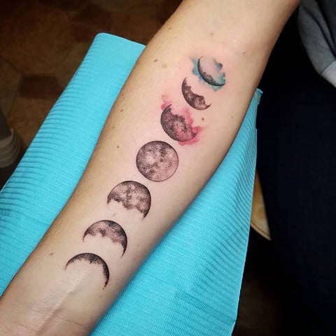 Tatuagens das fases lunares no antebraço realista com manchas da superfície lunar