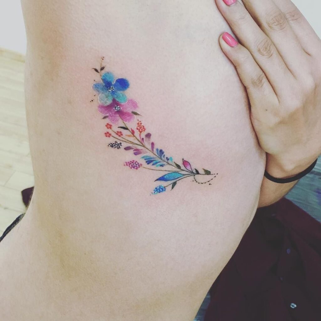 Tatuagens de flores nas costelas Pequeno buquê de flores rosa, azul e laranja