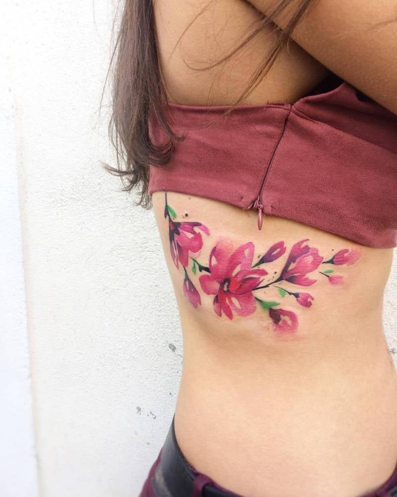 Tatuaggi floreali sulle costole Bouquet di fiori viola rosa