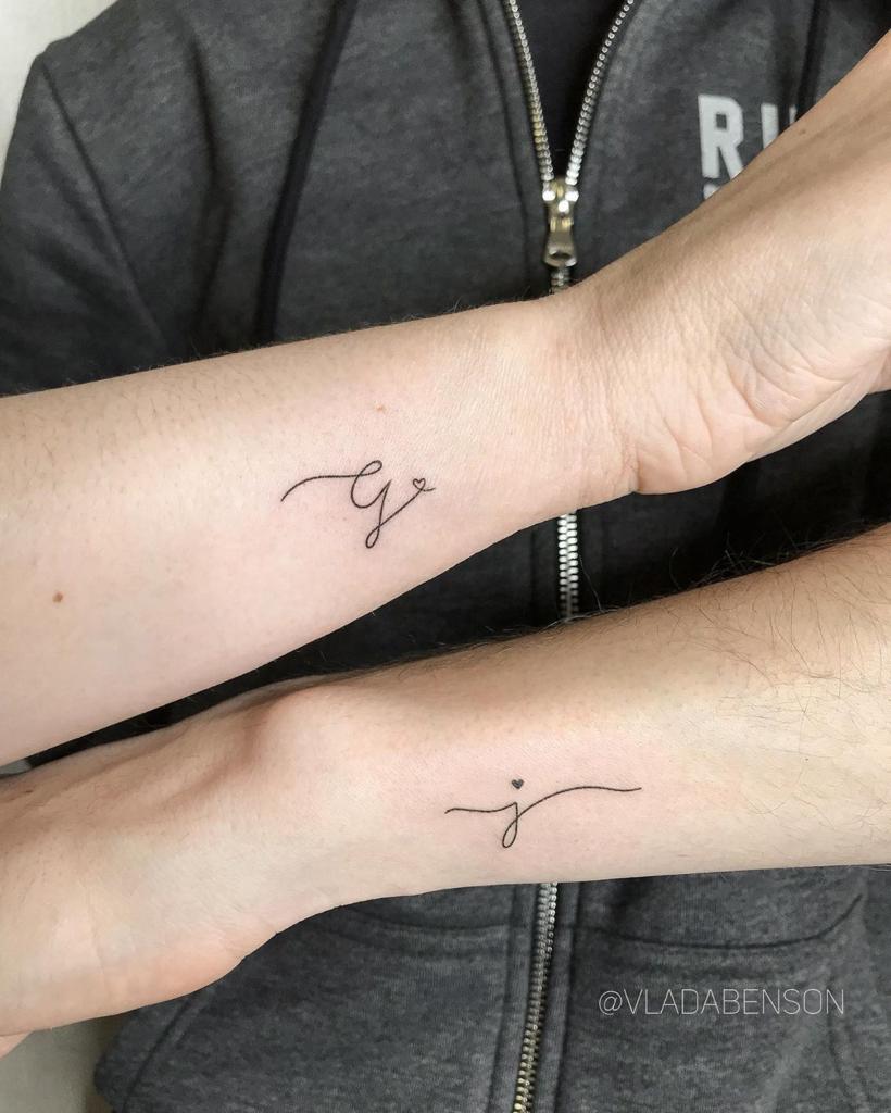 Tatuagens de Letras e Iniciais em ambos os lados do pulso as letras G e J em caligrafia e com pequenos corações